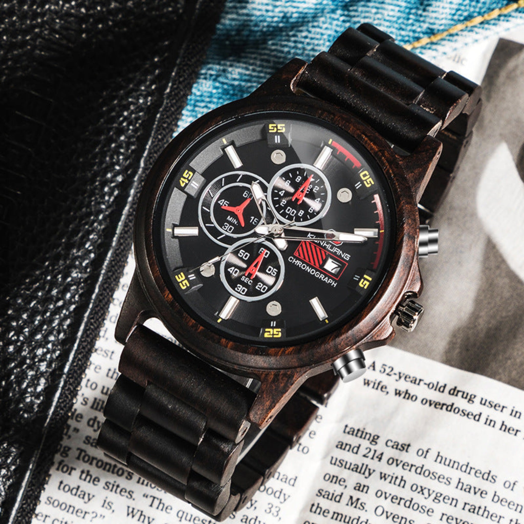 Black wristwatch with detailed face on a textured surface