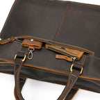 Brown leather briefcase with gold zipper pulls on a white background