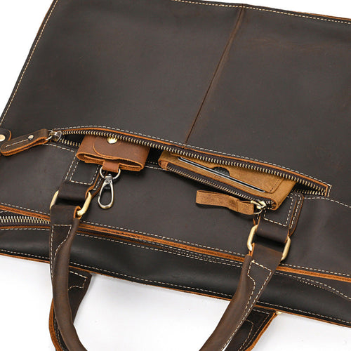 Brown leather briefcase with gold zipper pulls on a white background