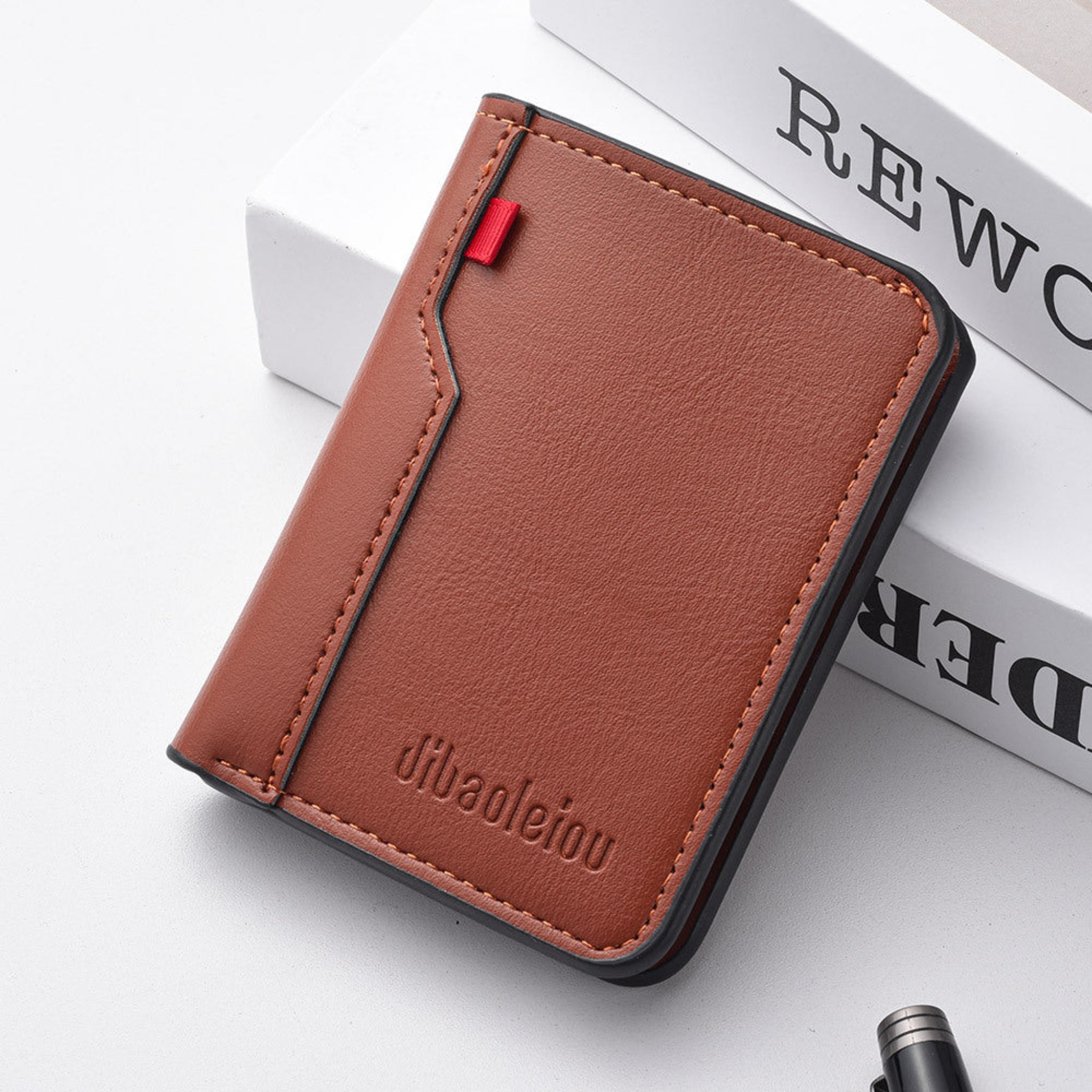 Brown leather wallet with a red tag on a white surface
